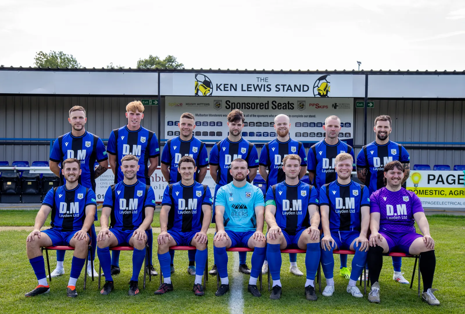 Mulbarton Wanderers' players in front of the Ken Lewis Stand at the Abode Arena, Mulberry Park, where Tuesday's replay will be played