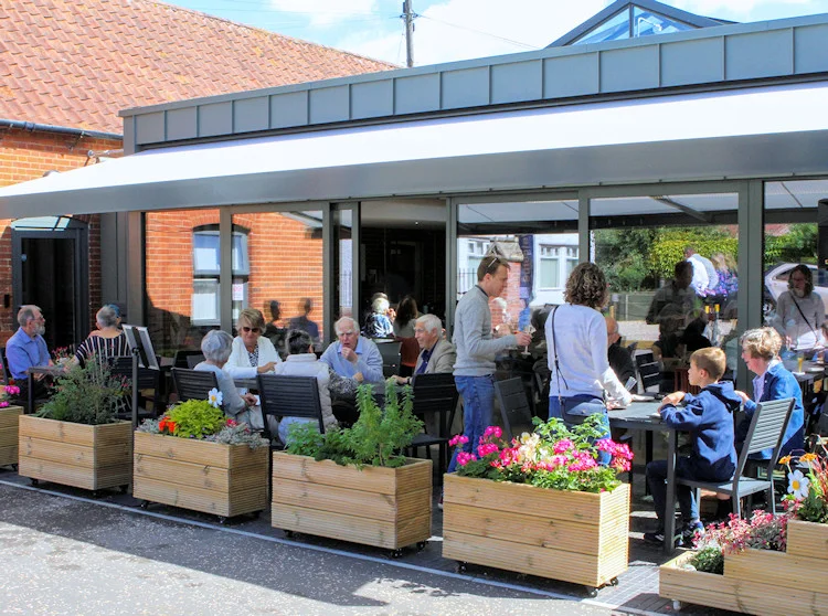 The Canopy, the new glass-fronted extension at Wymondham Baptist Church on Queen Street, with the Roots Community Café's outdoor tables